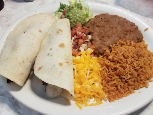 istock two tacos and rice and beans and cheese on plate 1184436303