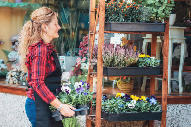 istock Young beautiful florist posing, smiling among plants. 1184436633