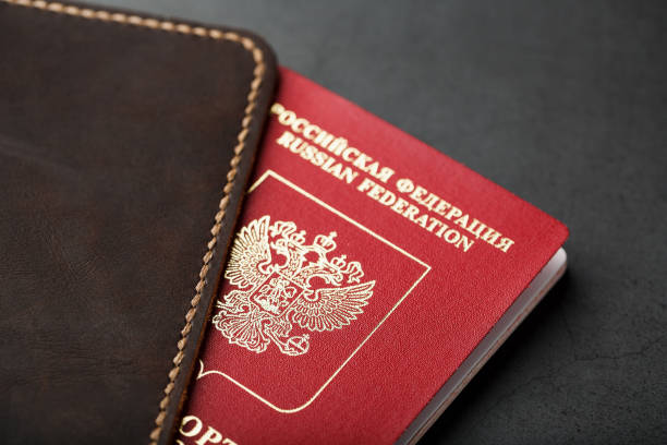istock Brown leather cover with a red passport on a dark background 1184436658