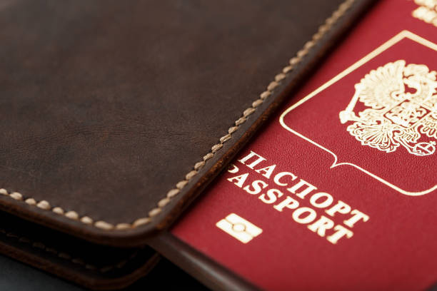 istock Brown leather cover with a red passport on a dark background 1184437283