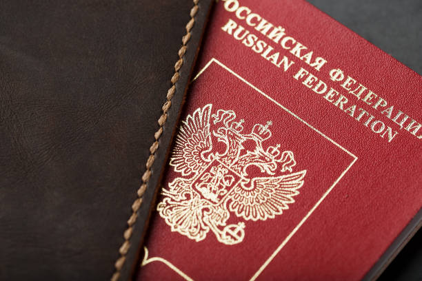 istock Brown leather cover with a red passport on a dark background 1184438117