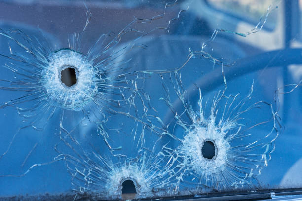 agujeros de bala en el cristal de seguridad frontal del coche. - bullet bullet hole hole glass fotografías e imágenes de stock