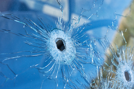 Agujeros de bala en el cristal de seguridad frontal del coche. photo
