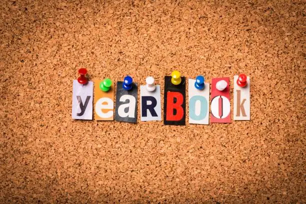 Yearbook - Cut out letters pinned on a cork notice board.