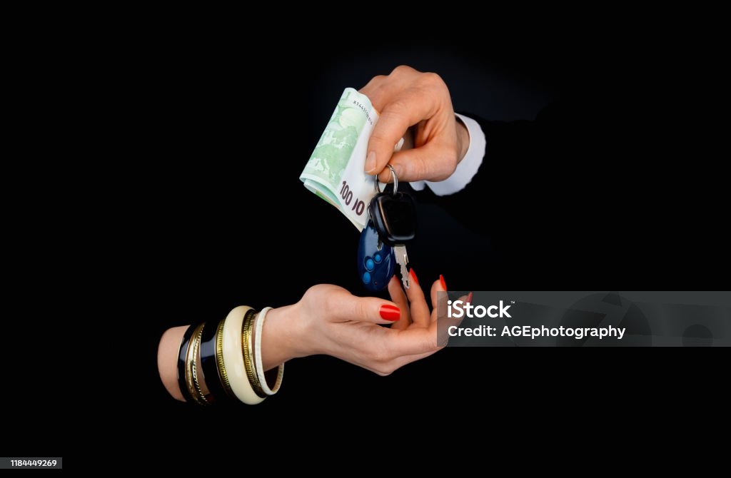 Mäns hand ger till kvinnans hand eurosedlar och bilnycklar - Royaltyfri Affärsman Bildbanksbilder