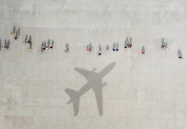 Aerial view of crowd with airplane shadow Aerial view of crowd with airplane shadow airport aerial view stock pictures, royalty-free photos & images