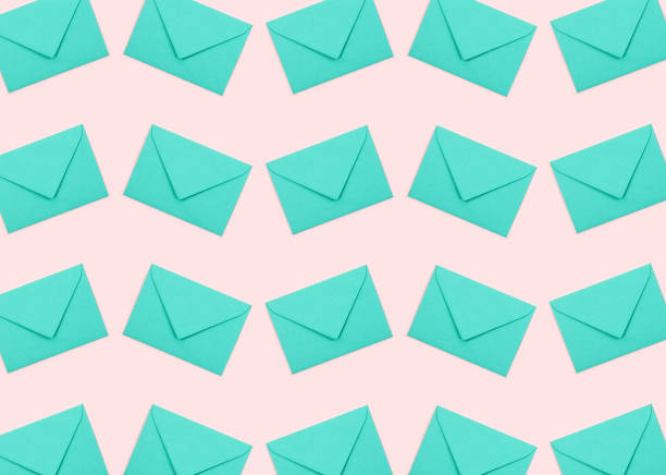 istock Pattern made of turquoise envelopes on pastel pink background. 1184450513