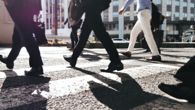 Close-up Led of Business Person Walking on Pedestrian Crossing of the Road, Commuting in Big City with Crowd of People on the Crosswalk, Slow motion