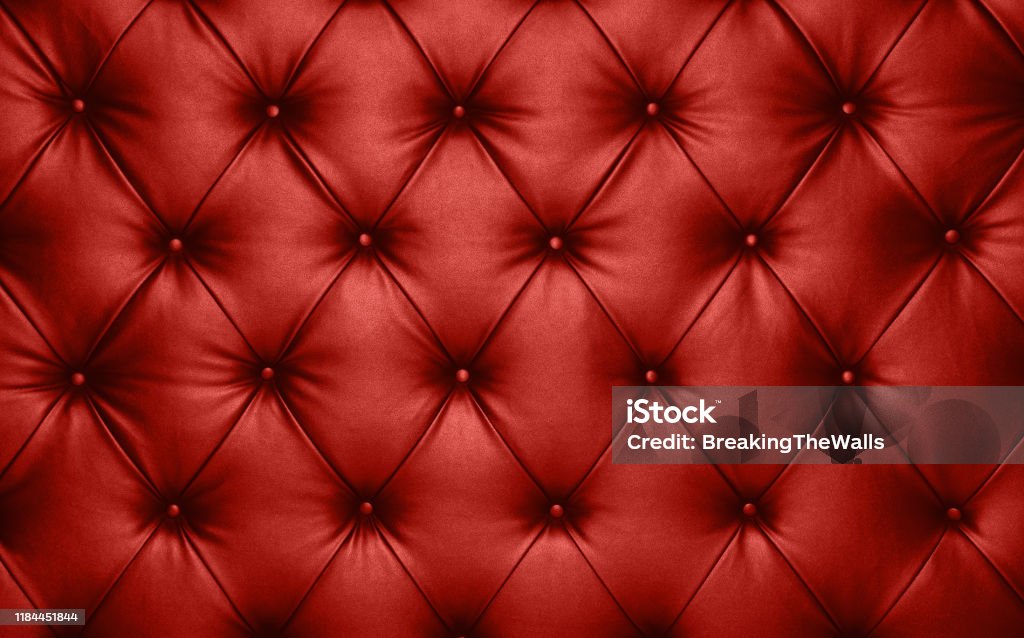 Red leather capitone background texture Close up background texture of scarlet red capitone genuine leather, retro Chesterfield style soft tufted furniture upholstery with deep diamond pattern and buttons Full Frame Stock Photo