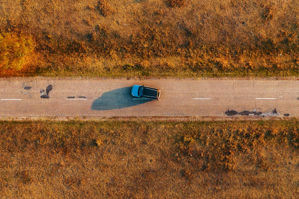 istock Car on the road through autumn countryside 1184451864