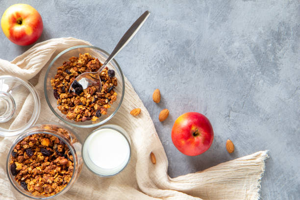 istock Granola with apples and cinnamon in a glass bowl on a gray background 1184452296