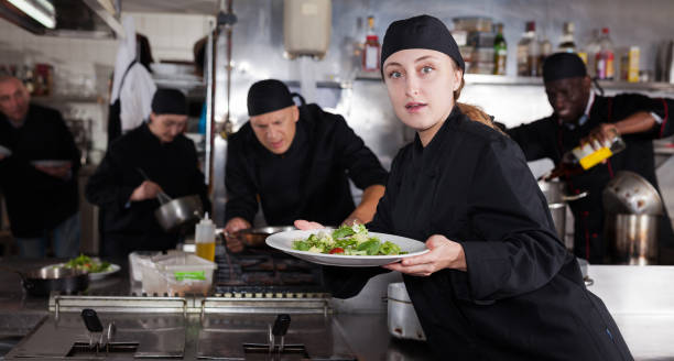 istock Confident female chef with a team of cooks in restaurant kitchen 1184453412