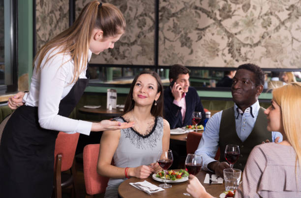 istock Positive company talking with waitress in restaurant 1184455621