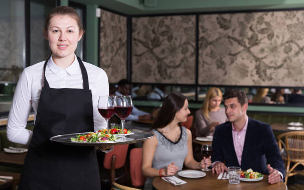 istock Polite waitress holding tray with dishes 1184455624