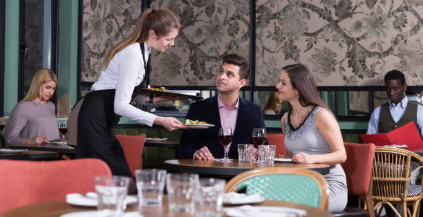 istock Waitress bringing dishes to couple 1184455626