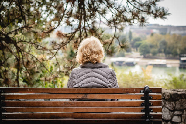 istock Senior woman sitting on the bench 1184458349