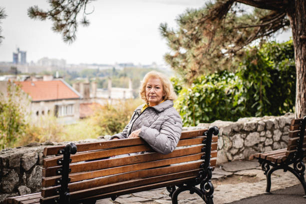 istock Senior woman sitting on the bench 1184458351