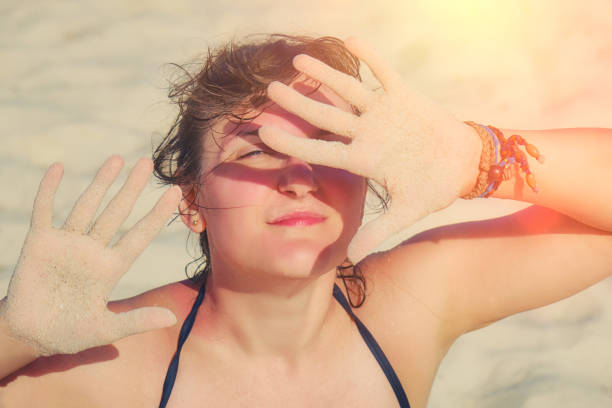 istock A woman protects her hands from the sun on the beach. 1184461908