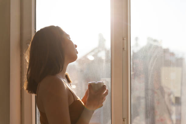istock Woman looking in home with coffee 1184462719