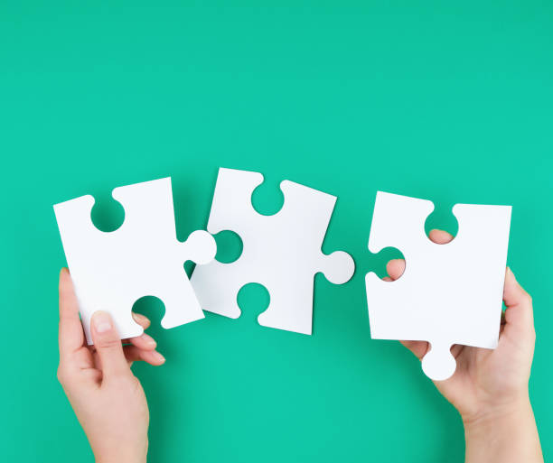 istock white big puzzles in female hand on green background 1184468107