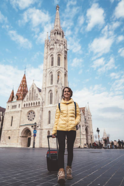 Tourist woman traveling solo in Budapest Young woman with suitcase at the castle hill-budapest fishermens bastion photos stock pictures, royalty-free photos & images