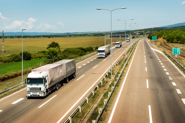 istock White Lorry trucks in line on a country highway 1184472547