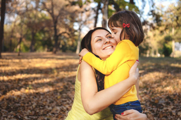 istock Mother with daughter in autumn park 1184477840