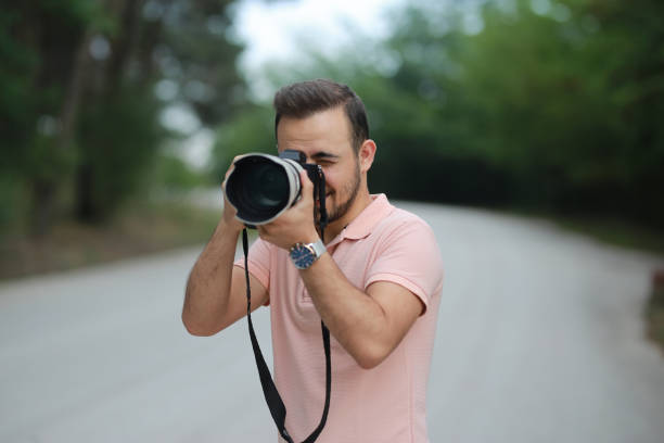 istock Male photographer with professional camera on blurred background. Space for text 1184483194