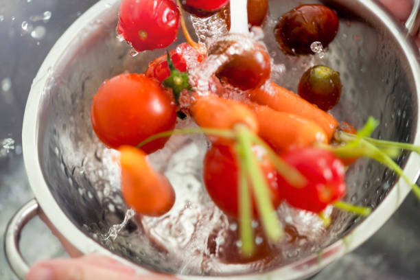 istock Washing tomatoes and carrots in the sink. 1184486404
