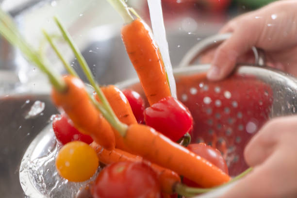 istock Washing tomatoes and carrots in the sink. 1184486408