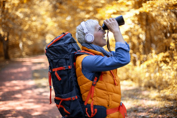 istock Senior women with binoculars in forest. 1184488814