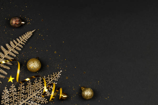 istock Golden branches, balls, serpentine and confetti on a black background. 1184489883