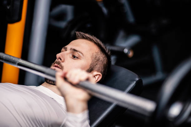zdrowy człowiek trzyma trening hantle i budowanie ciała na siłowni. - muscular build chest body building sport zdjęcia i obrazy z banku zdjęć