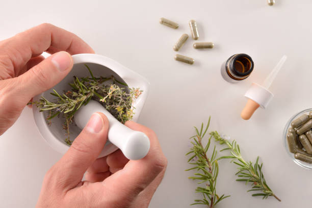 istock Hands elaborating alternative medicine with plants with mortar top view 1184495030