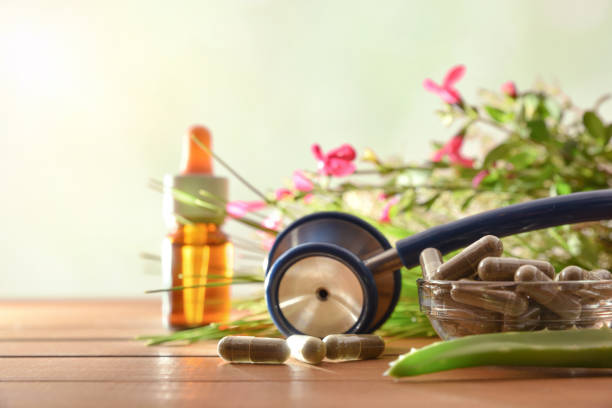 cápsulas de medicina herbaria natural en pantalones de mesa y frente de frasco - naturopath fotografías e imágenes de stock