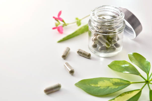 istock Natural medicine capsules in open glass jar on table elevated 1184495054