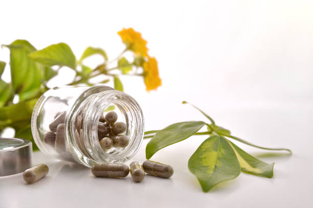 istock Natural medicine capsules in open glass jar on table front 1184495297