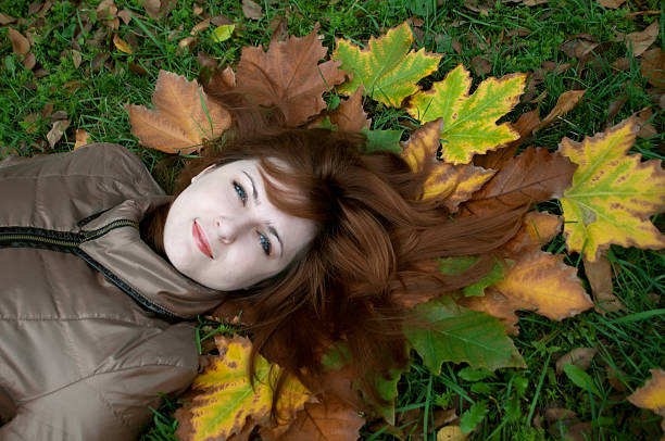 istock Young beautiful ginger lying on the autumn leaves 118449609