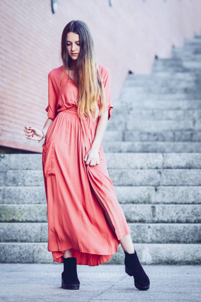 istock beautiful young woman posing on stairs 1184496593