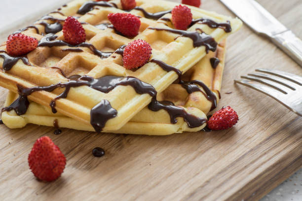 Viennese waffles with chocolate and berries on a wooden Board
