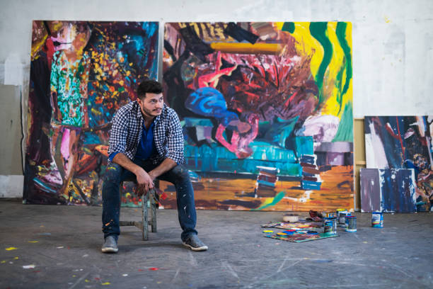 istock Young Artist working on big painting 1184502692