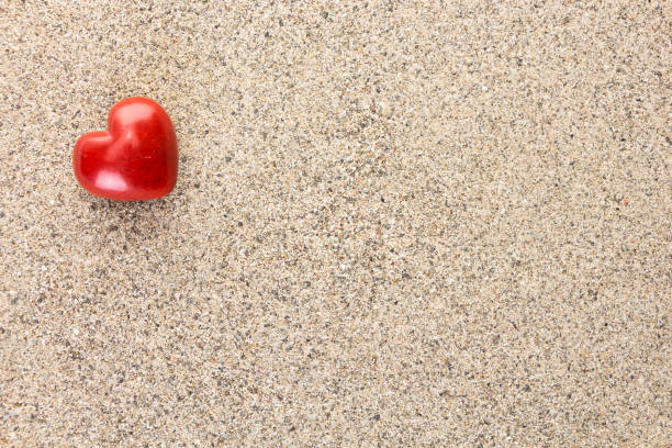 Love heart drawn in dry sand.