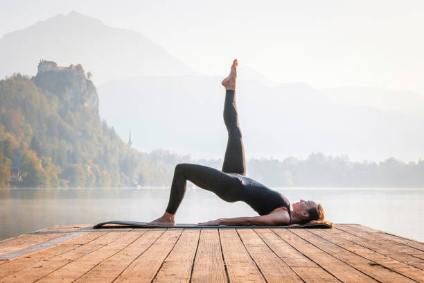 istock Yoga One Legged Bridge Position on Lake Bled in Morning 1184503077