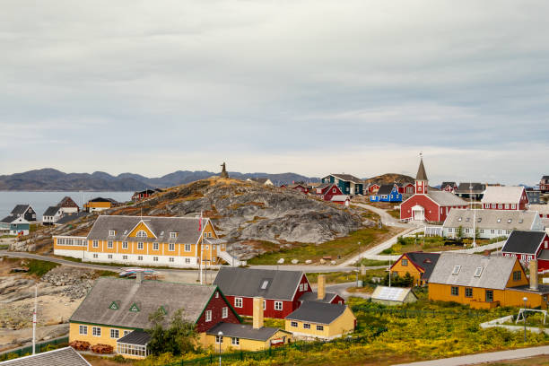 Colorful houses with the school Det gamle Sygehus, the cathedral and the statue of Hans Egede in the background, Nuuk. stock photo