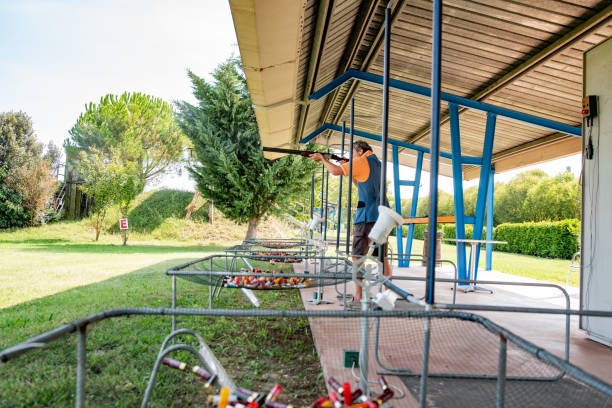 Adult Man Practicing Skeet Shooting on Shooting Range Adult Man Practicing Skeet Shooting on Shooting Range. trap shooting stock pictures, royalty-free photos & images