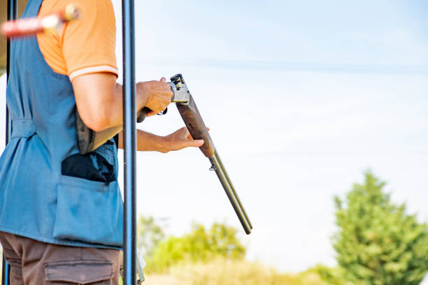 istock Adult Man Reloading Shotgun Cartridge on Shooting Range 1184506576