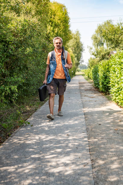 istock Mature Man Walking To a Skeet Shooting Range With Rifle 1184506579