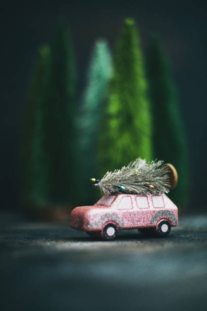 Pink car transporting Christmas tree. Christmas holiday background.