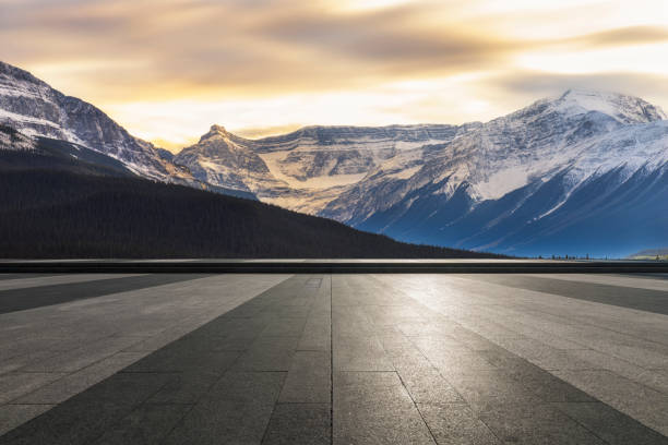 istock Sunset view of snowy mountains with empty patio on foreground 1184512110