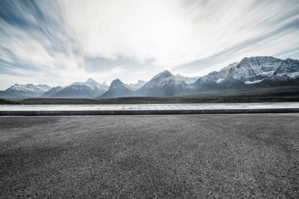 istock Empty tarmac road with dramatic landscape on background 1184512994